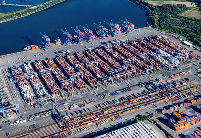Luftaufnahme des Altenwerder Hafens in Hamburg mit zahlreichen Containern und Kranen. Container sind in verschiedenen Farben angeordnet.