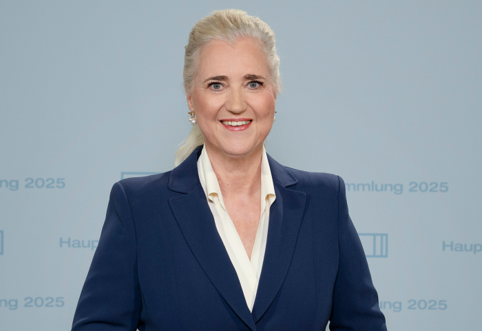 HHLA-CEO Angela Titzrath stehend vor einem Hintergrund mit dem Schriftzug 'Hauptversammlung 2025'