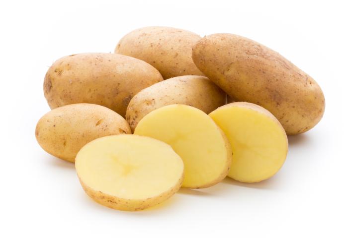 Mehrere braune Kartoffeln, davon eine in drei Scheiben geschnitten, auf weißem Untergrund