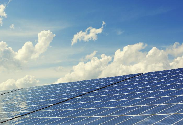 Solarmodule auf einem Dach unter blauem Himmel mit weißen Wolken