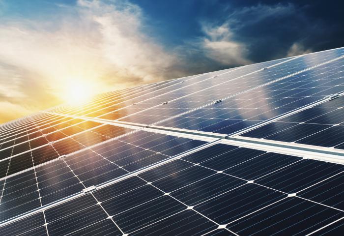 Solarmodule auf einem Dach bei Sonnenuntergang mit teilweise bewölktem Himmel