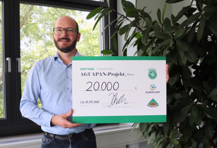 Dr. Justis Boehm mit einem Scheck