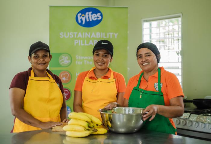 Drei Frauen mit Schürze, Schüssel und Bananen