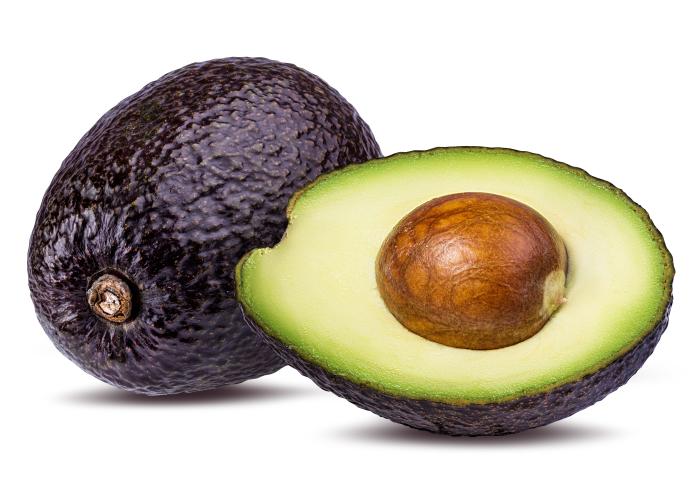 eine ganze und eine halbe Avocado, bei der halben ist sowohl Fruchtfleisch, als auch der Kern sichtbar