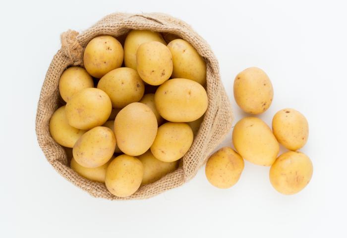 Kartoffeln im Sack und daneben liegend