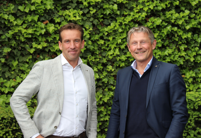 Hilbert Klop und Jan van den Adel stehen vor einer grünen Efeu-Wand