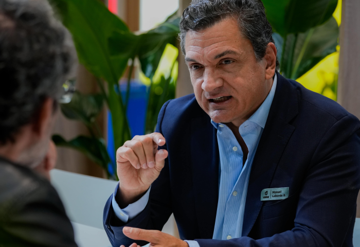 Manuel Laborde Barriga sitzt an einem Tisch, ist im Gespräch und gestikuliert dabei