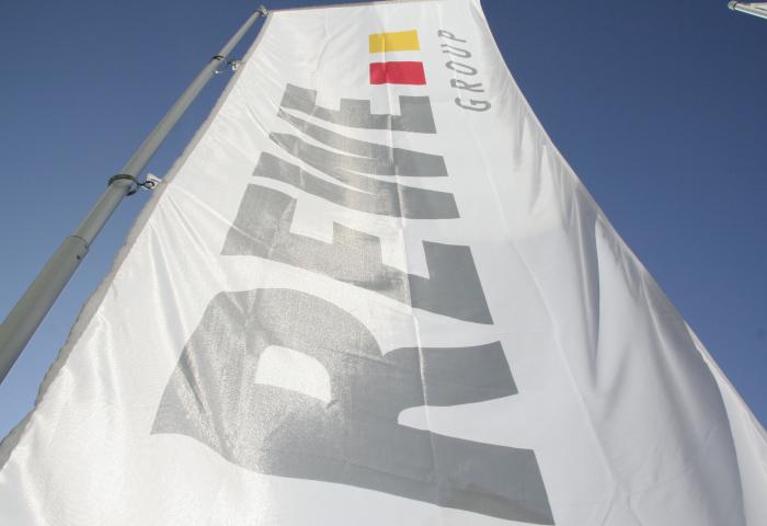 Flagge mit dem Text 'REWE GROUP' in großen, grauen Buchstaben und einem roten sowie gelben Rechteck in der oberen rechten Ecke.