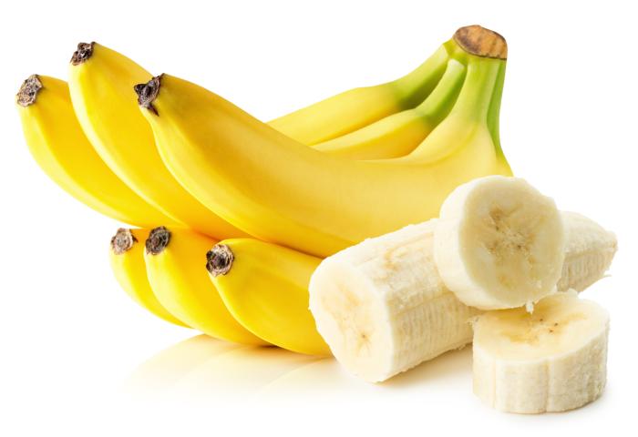 Sechs reife Bananen und eine geschälte Banane teilweise in Scheiben geschnitten