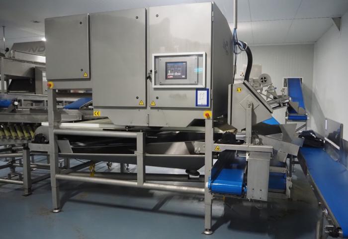 Große industrielle Maschine mit mehreren Förderbändern und Steuerungstafel in einer Produktionshalle