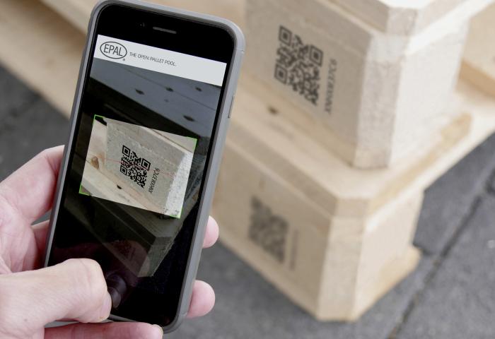 Mit Smartphone wird QR-Code auf Palette gescannt