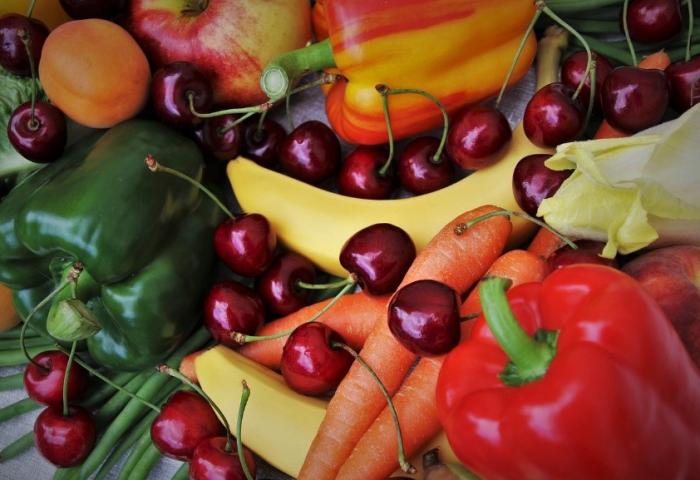 Nahaufnahme von roten und grünen Paprikaschoten, Bananen, Karotten, Kirschen und Aprikosen