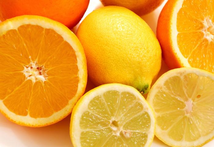 ganze und halbe Orangen und Zitronen