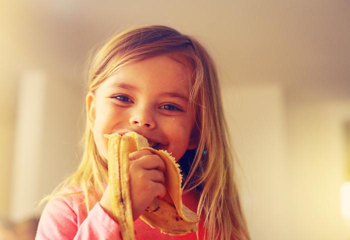 blondes Mädchen isst Banane