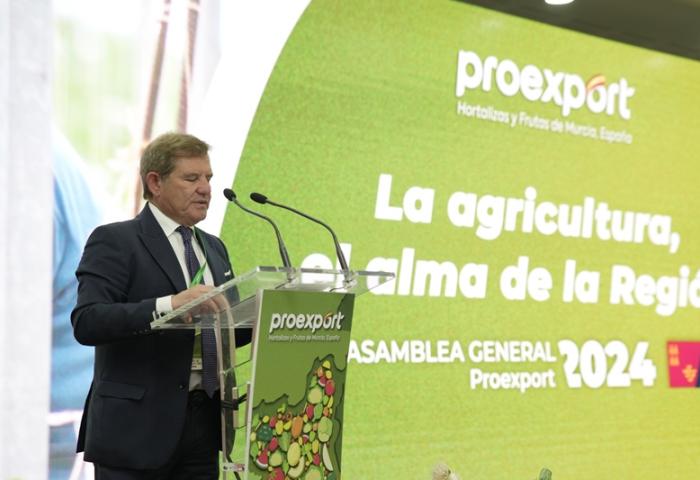 Mariano Zapata steht am Rednerpult mit Mikrofonen, im Hintergrund eine grün-gelbe Präsentationswand mit dem Text 'proexport', 'La agricultura, el alma de la Región', 'ASAMBLEA GENERAL Proexport 2024'.
