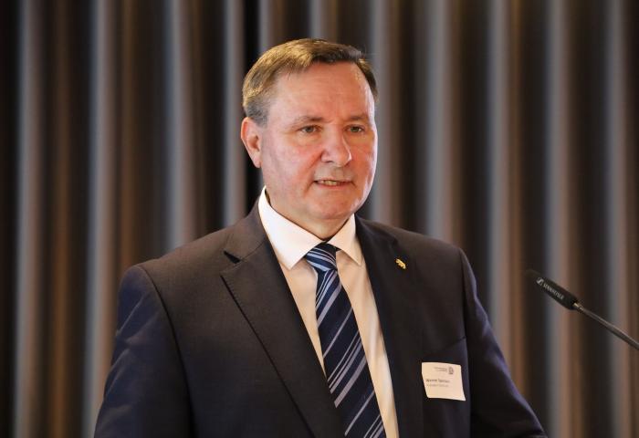 Werner Salzmann steht an einem Rednerpult mit Mikro