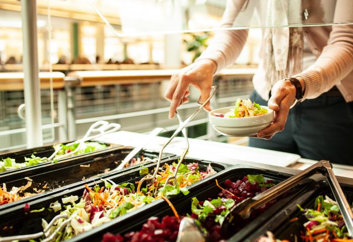 Person holt sich Essen in der Kantine