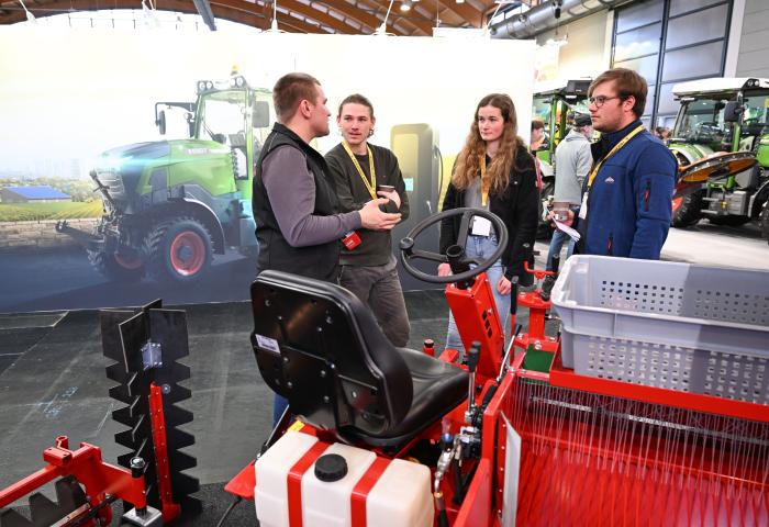 Menschen unterhalten sich neben einem Traktor