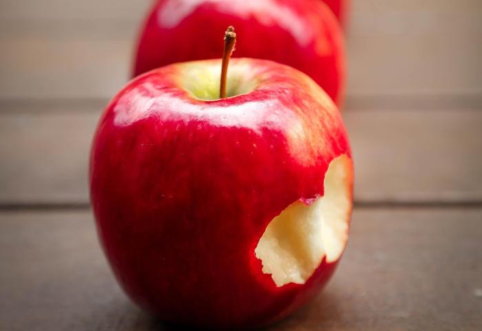 Reihe mit roten Äpfeln, einer ist angebissen