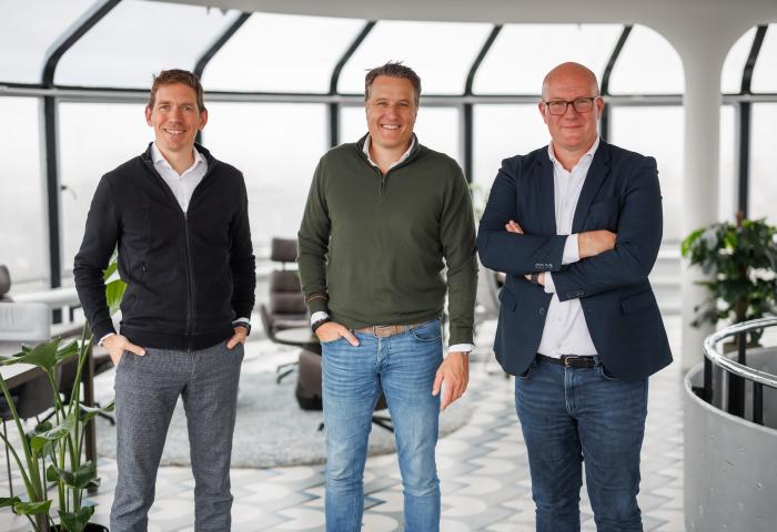 Drei Männer stehen in einem Büro