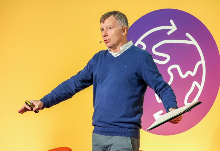 Philip Gray steht auf einer Bühne der Fruit Logistica. Im Hintergrund das Logo des Logistics Hub.