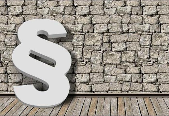 Paragraf-Symbol vor Mauer