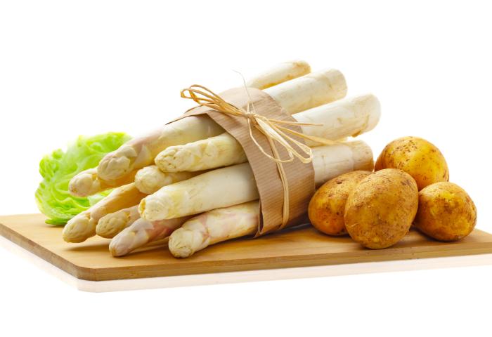 Spargelstangen mit Kartoffeln auf einem Brett