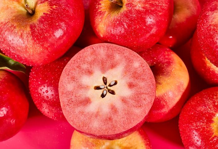 halbierter und ganzer rotfleischiger Apfel Fizz