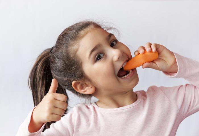 Mädchen isst Möhre