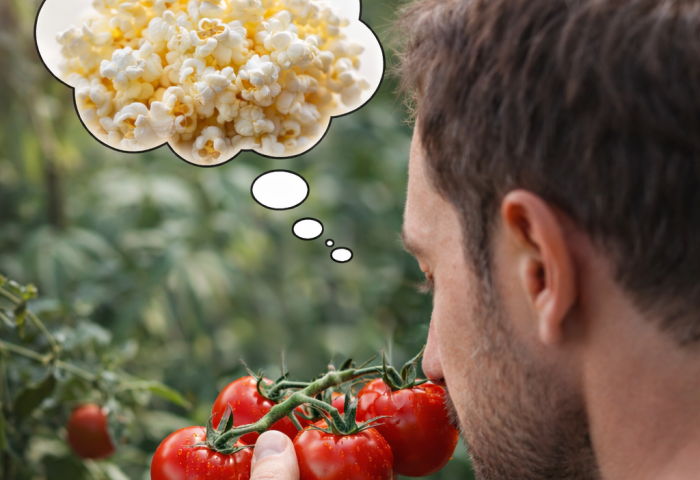Mann riecht an Tomaten und denkt an Popcorn