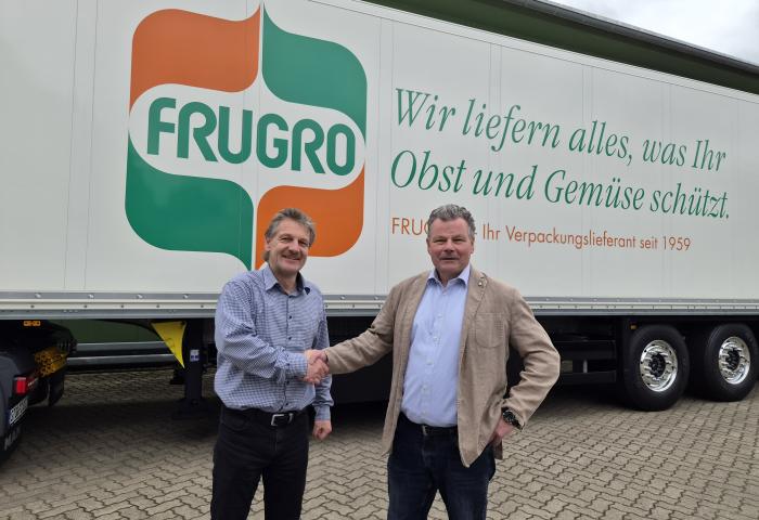 zwei Männer schütteln die Hände vor einem Lkw