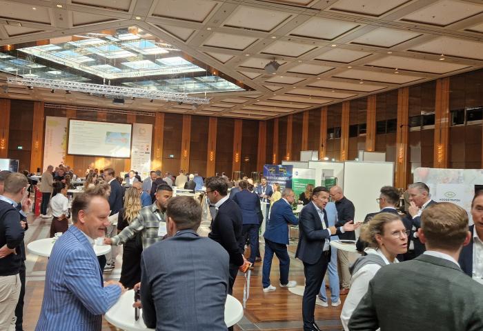 Teilnehmende des Deutschen Obst- und Gemüsekongresses (DOGK) 2026 im Veranstaltungsraum in Düsseldorf im Gespräch an Stehtischen und Ausstellerständen.
