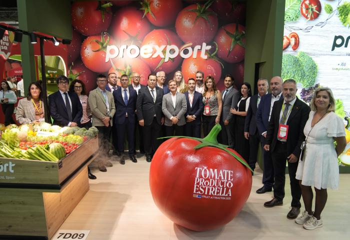 Menschen stehen vor riesiger Tomate an Messestand