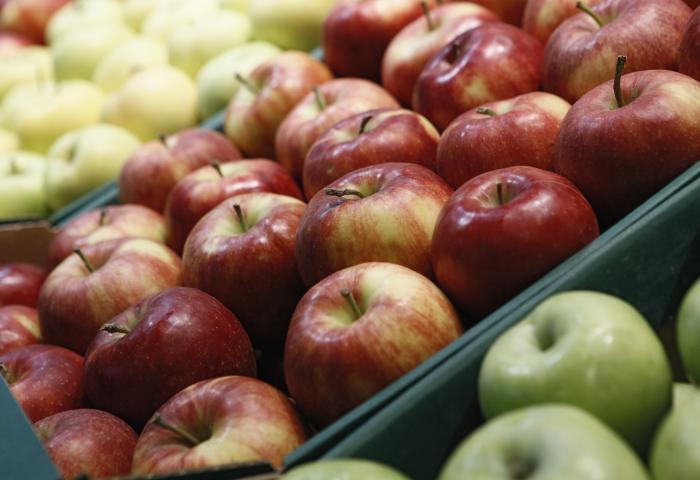 Grüne und rote Äpfel in Plastiksteigen
