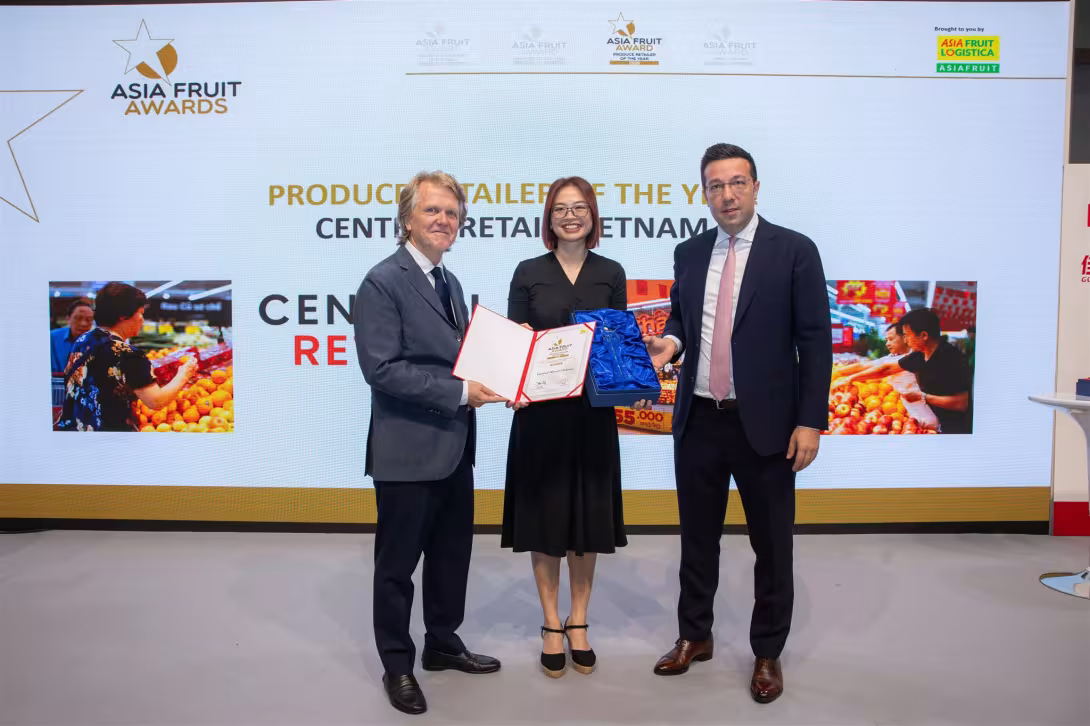 Pham Dieu Linh in der Mitte erhält einen Award von Chris White links und David Axiotis rechts. Hintergrund zeigt 'ASIA FRUIT AWARDS' und 'CENTRAL RETAIL VIETNAM'.