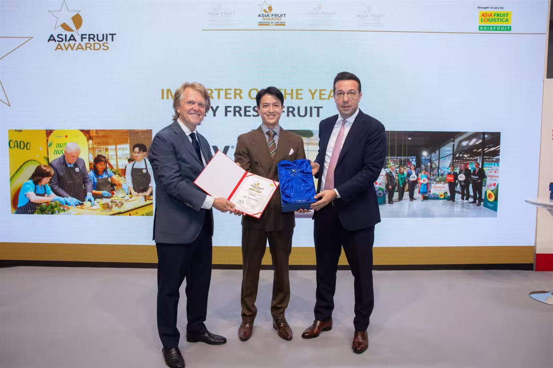 Chris White (links) und David Axiotis (rechts) übergeben den Award an Wongsakorn Chatamornwong.