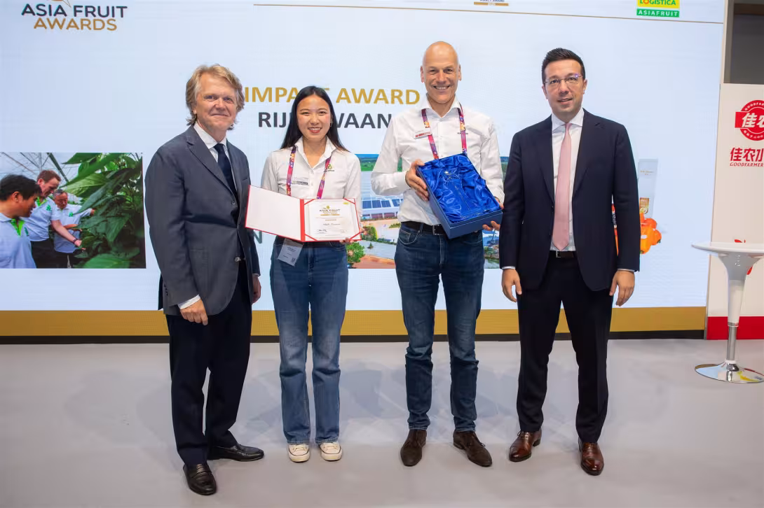 Jan Doldersum (2.v.r.) erhält den Asia Fruit Award von Chris White (l.) und David Axiotis (r.). Doldersum hält eine Urkunde und eine blaue Geschenkbox.